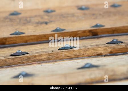 Details der Bolzen an der Nachbildung des Sutton Hoo Longship, im Longshed in Woodbridge, Suffolk. Drei Auszubildende machen ein zweiwöchiges Praktikum bei der Sutton Hoo Ship's Company, die die Arbeit an der 88ft m langen Nachbildung leitet. Foto: Freitag, 11. August 2023. Stockfoto