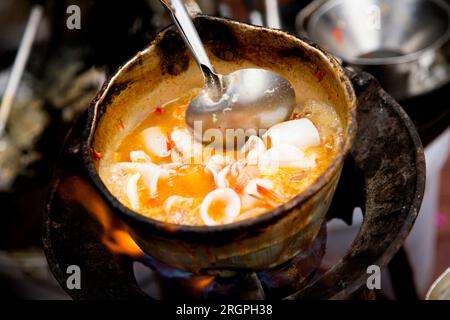 Tintenfische mit rotem Curry an einem Street Food Stand in Bangkok, Thailand. Stockfoto