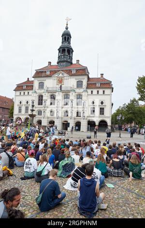 11. August 2023, Niedersachsen, Lüneburg: Die Teilnehmer des protestmarsches der Klimabewegung Fridays for Future haben sich vor dem Rathaus auf dem Marktplatz versammelt. Die Demonstration durch Lüneburg soll unter anderem die Aufmerksamkeit auf die Notwendigkeit der neuen Eisenbahnstrecke Hamburg-Hannover lenken. Foto: Georg Wendt/dpa Stockfoto