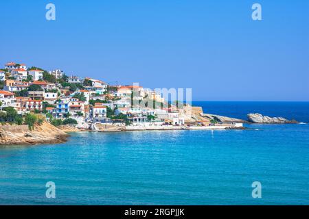 Schönes griechisches Fischerdorf Armenistis an einem ruhigen Sommermorgen. Hafen mit lokalem Strand in transparentem klarem Wasser in Ikaria, Griechenland Stockfoto