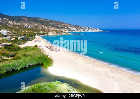 Schönes griechisches Fischerdorf Armenistis an einem ruhigen Sommermorgen. Hafen mit lokalem Strand in transparentem klarem Wasser in Ikaria, Griechenland Stockfoto