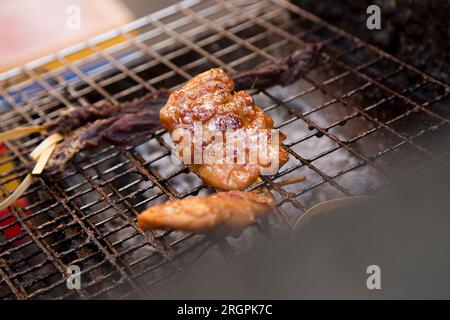 Schweinespieße in einem Streetfood-Stall in Bangkok in Thailand. Stockfoto