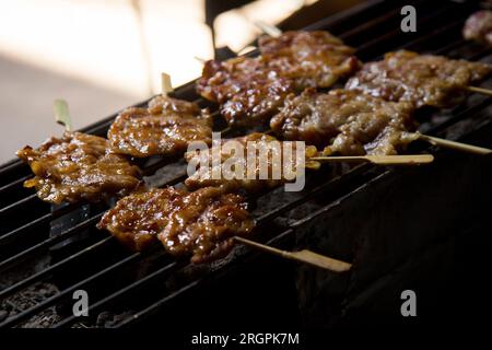 Schweinespieße in einem Streetfood-Stall in Bangkok in Thailand. Stockfoto