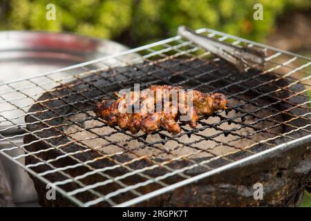 Schweinespieße in einem Streetfood-Stall in Bangkok in Thailand. Stockfoto