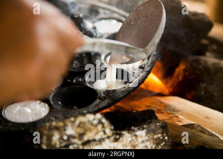 Frau bereitet Kokosnuss-thai-Desserts zu. Kanom krok ist ein leckeres thailändisches Mini-Pfannkuchen auf Kokosnussmilchbasis, das ebenfalls beliebt ist. Stockfoto