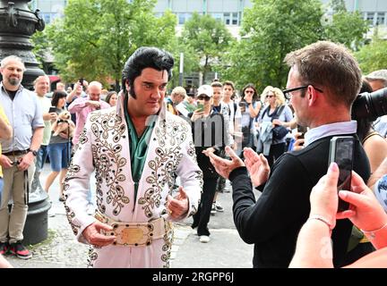 Berlin, Deutschland. 11. Aug. 2023. Der Elvis-Künstler Grahame Patrick aus der Serie „Stars in Concert“ kommt zum Wachsfigurenkabinett Madame Tussauds Berlin, um eine frisch restaurierte Elvis-Figur zu enthüllen. Zuvor wurde die Figur in US-Armeeuniform dargestellt, die der Sänger 1958 während seines Militärdienstes in Westdeutschland trug. Nach 15 Jahren im Dienst des Wachsmuseums hat Elvis in den letzten Monaten ein neues Outfit und eine neue Frisur erhalten. Kredit: Soeren Stache/dpa/Alamy Live News Stockfoto