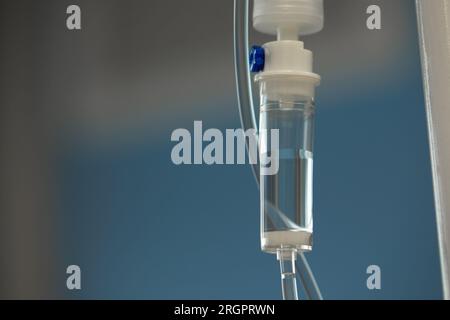 Nahaufnahme des Infusionsschlauchs. Aktion. Dropper mit Medikament tropft langsam in den Schlauch. Intravenöse Röhrchen für kranke Patienten nach der Operation Stockfoto