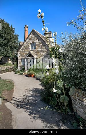 Unteres Schlachthaus, Cotswold, traditionelles, aus Stein gebautes, malerisches Landhaus mit großer Blume, England, Großbritannien, Stockfoto