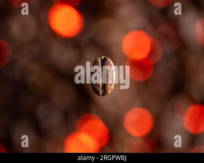 Feuer Geröstete Kaffeebohnen Produkt Shot (Macro). Nahaufnahme einer Kaffeebohne mit feurigem Hintergrund. Stockfoto