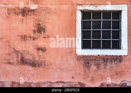 Alte rote Backsteinwand mit zwei rostigen Grillfenstern. Stockfoto