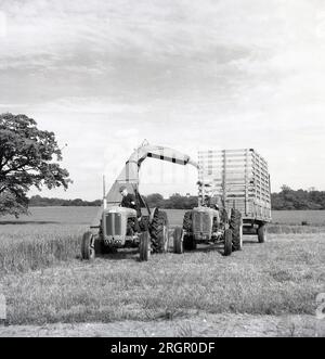 1950er, historisch, ein Landwirt auf einem Traktor mit angebauter Erntemaschine, mit einem anderen Landwirt und einem Traktor mit Holzlattanhänger daneben, um die geerntete Ernte zu fangen, England, Großbritannien. In dieser Zeit, in der die Nachkriegsbeschränkungen noch immer gelten, war die Landwirtschaft ein wichtiger Wirtschaftszweig, und - schwer zu glauben heute - der größte Teil der Landmasse Großbritanniens war immer noch überwiegend ländlich und landwirtschaftlich. Stockfoto