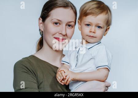 Junge glückliche Frau in warmer Winterkleidung hält Schnee in den Händen Stockfoto