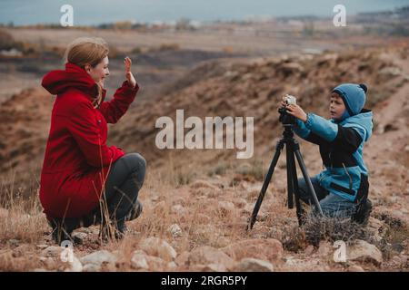 Der Junge fotografiert seine Mutter in den Bergen Stockfoto