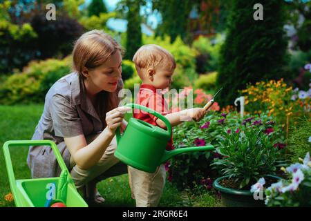 Eine junge Frau und ihre einjährige Kinderbetreuungsblume im Garten Stockfoto