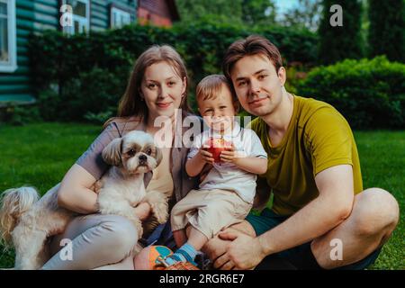 Junge Eltern mit einem einjährigen Kind und Hund auf dem Gelände Stockfoto