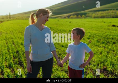 Glückliche Mutter und Sohn auf dem Feld, die sich an einem sonnigen Tag ansehen Stockfoto