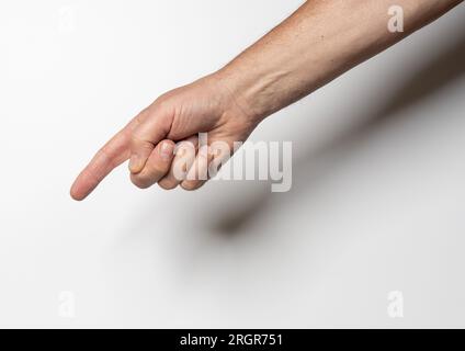 Eine männliche Hand, die mit einem Finger auf einen weißen Hintergrund zeigt Stockfoto