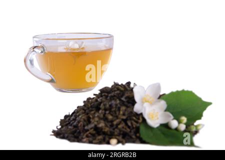 Getrocknete Teeblätter, frische Jasminblüten mit grünen Blättern und Glas-Teetasse, isoliert vor weißem Hintergrund präsentiert Stockfoto