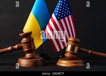 Zwei Hammer mit USA-Flagge und ukrainischer Flagge auf schwarzem Hintergrund Stockfoto