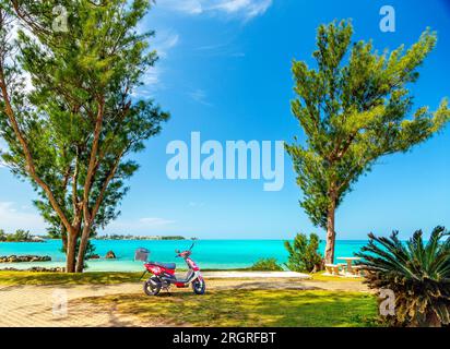 Ein Motorroller parkt an einem wunderschönen Strand und Picknickbereich auf Bermuda. Stockfoto