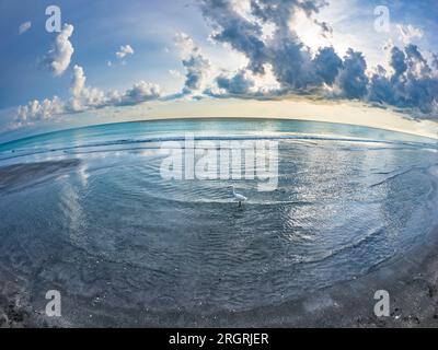 Blick aus der Fischaugenlinse auf die Sonne und die Wolken am späten Nachmittag über dem Golf von Mexiko vom Venice Beach in Venice, Florida, USA Stockfoto