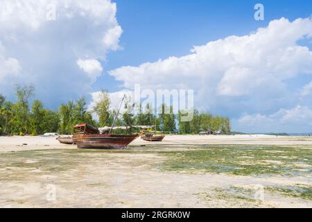 Fischerboote aus Holz liegen am Strand wegen Ebbe im Dorf Kendwa, sonniger Tag, Sansibar, Tansania Stockfoto