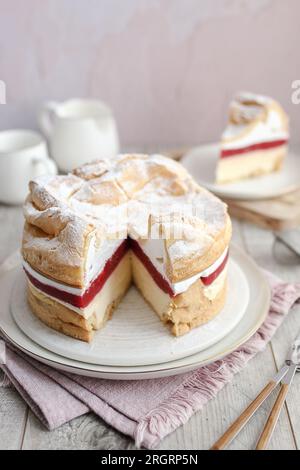 Polnischer Karpaten-Kuchen Karpatka. Creme Puffkuchen mit Erdbeeren. Holztisch und rosafarbener Hintergrund. Stockfoto