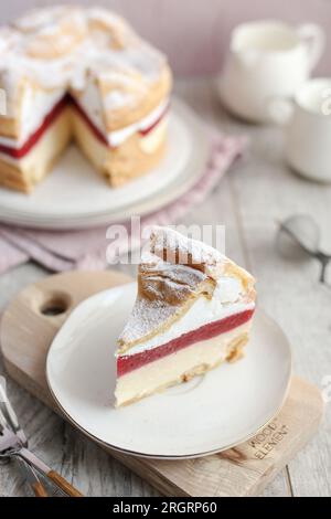 Polnischer Karpaten-Kuchen Karpatka. Creme Puffkuchen mit Erdbeeren. Holztisch und rosafarbener Hintergrund. Stockfoto