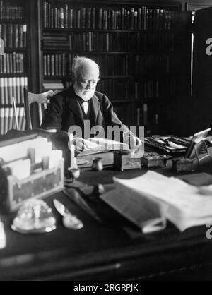 New York, New York: 5. April 1913 Andrew Carnegie liest ein Buch an seinem Schreibtisch. Stockfoto