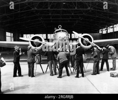 Vereinigte Staaten: 1937 Fotografen, die Fotos von (L-R), Paul Mantz, Amelia Earhart, Harry Manning und Fred Noonan machen; alle posierten vor Earharts Lockheed Electra 10E Stockfoto