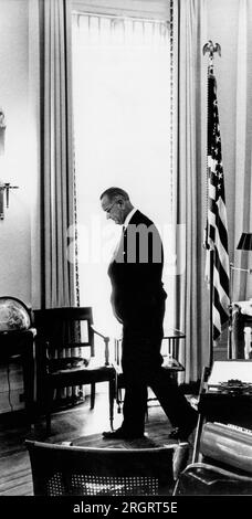 Washington, D.C.: 11. Dezember 1965 Präsident Lyndon Johnson geht in seinem Weißen Büro auf die Bühne und analysiert dabei ein aktuelles Problem. Stockfoto