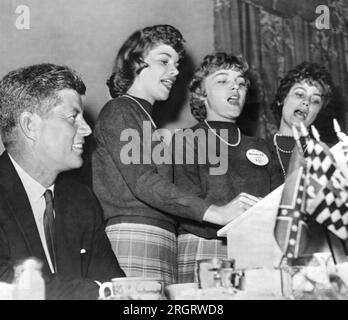 Charleston, West Virginia: 19. September 1960 Ein lächelnder Senator John F. Kennedy hört den Bloomfield-Schwestern zu, wie sie den West Virginia Democratic-Wahlkampfsong singen, der in Charleston auftaucht. Stockfoto