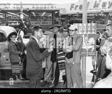 Portland, Oregon: 25. Mai 1960 Senator John Kennedy von Massachusetts führt zwei Tage vor der Hauptwahl in Oregon Kampagnen im Gateway Shopping Center durch. Die Mitglieder der Fun-O-Rama-Spaßmacher hören aufmerksam zu. Stockfoto