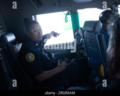 Honolulu, Hawaii, USA. 10. Aug. 2023. Barney Hanson, Captain der Feuerwehr von Honolulu, beobachtet die Insel Maui am 10. August 2023, während er an Bord eines C-17 Globemaster III fliegt, der von Mitgliedern der 204. Luftaufzugsstaffel betrieben wird. Eine Luftwaffe der Hawaii Air National Guard aus dem 204. Airlift Squadron flog das Flugzeug auf die Insel Maui, um Hilfe und Ressourcen für Gemeinden zu liefern, die von mehreren Waldbränden betroffen waren. (Kreditbild: © John Linzmeier/USA National Guard/ZUMA Press Wire) NUR FÜR REDAKTIONELLE ZWECKE! Nicht für den kommerziellen GEBRAUCH! Kredit: ZUMA Press, Inc./Alamy Live News Stockfoto