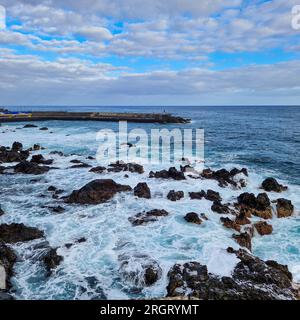 Bei Sonnenaufgang erwacht Puerto de la Cruz mit der sanften Umarmung der Morgensonne. Die Stadt, immer noch in den Überresten der Nacht eingewickelt, beginnt zu schwingen Stockfoto