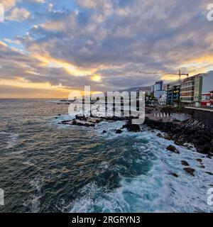 Bei Sonnenaufgang erwacht Puerto de la Cruz mit der sanften Umarmung der Morgensonne. Die Stadt, immer noch in den Überresten der Nacht eingewickelt, beginnt zu schwingen Stockfoto