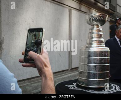 Ein Mann mit Telefon macht ein Foto vom Stanley Cup in Riga, Lettland Stockfoto