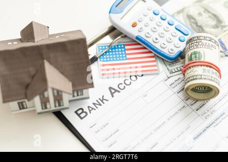 Modellhaus und Dollar-Geld mit Vertrag Papier auf dem Tisch. Darlehen zu Hause Finanzierung Konzept. Stockfoto