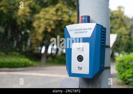 Notruftaste in einem öffentlichen Stadtpark. SOS, Polizei, Panik. Konzept der Personensicherheit. Notruf für Hilfe. Stockfoto