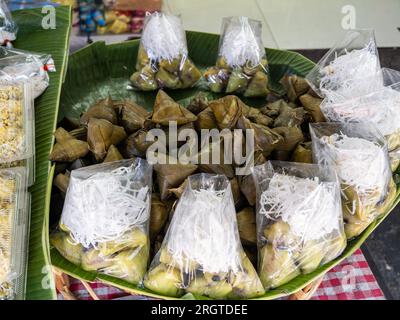 An einem Imbissstand in Bangkok, Thailand, finden Sie „iew Bak Chang“ - Bananenblätter verpackte Pakete mit Glutinösem Reis und Schweinefleisch Stockfoto