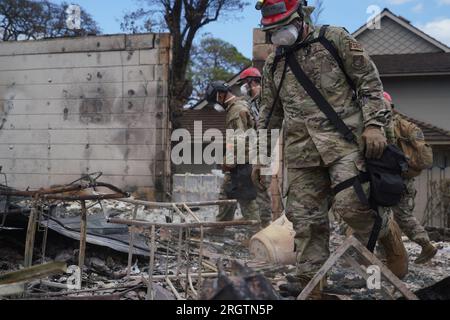 Lahaina, Usa. 10. Aug. 2023. Die Hawaii Army National Guard SAR-Soldaten durchsuchen die Überreste ausgebrannter Häuser nach den Waldbränden, die den Großteil der historischen Stadt am 10. August 2023 in Lahaina, Maui, Hawaii, zerstörten. Waldbrände, die von starken Winden angefacht wurden, haben mindestens 55 Menschen getötet und Tausende von Häusern auf der Insel zerstört. Kredit: MSgt. Andrew Jackson/US Air Force Photo/Alamy Live News Stockfoto