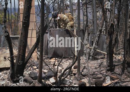 Lahaina, Usa. 10. Aug. 2023. Die Hawaii Army National Guard SAR-Soldaten durchsuchen die Überreste ausgebrannter Häuser nach den Waldbränden, die den Großteil der historischen Stadt am 10. August 2023 in Lahaina, Maui, Hawaii, zerstörten. Waldbrände, die von starken Winden angefacht wurden, haben mindestens 55 Menschen getötet und Tausende von Häusern auf der Insel zerstört. Kredit: MSgt. Andrew Jackson/US Air Force Photo/Alamy Live News Stockfoto