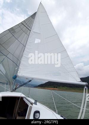 Nahaufnahme von Teilen eines Segelboots, das segelt: Mast, Hauptsegel, Leinwand, Ruder, Bug, stern, wetterfahne, Boom, Jib Stockfoto