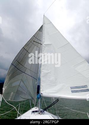 Nahaufnahme von Teilen eines Segelboots, das segelt: Mast, Hauptsegel, Leinwand, Ruder, Bug, stern, wetterfahne, Boom, Jib Stockfoto