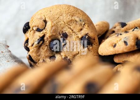 Weizenmehlkekse und große Stücke süßer Schokolade zusammen, Kekse mit Schokoladenstücken in der Nahaufnahme, Stockfoto