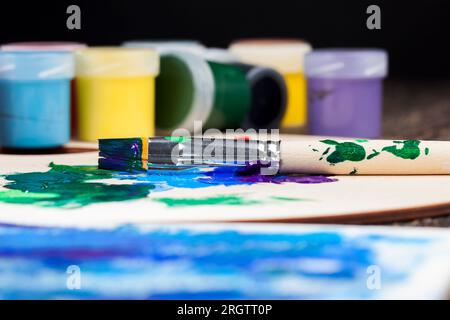 Der kreative Prozess des Zeichnens durch Mischen verschiedener Farben von Farben mit Kunstbürsten, Kunstpinseln und Farben für Malbilder, Öl und andere Pai Stockfoto