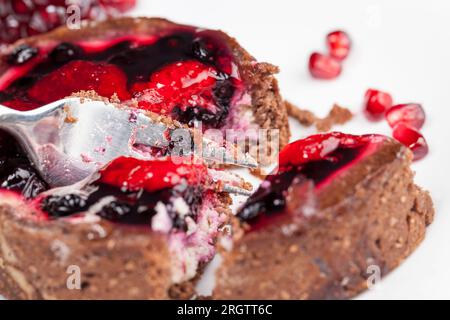 Rundes Törtchen mit Erdbeeren und Blaubeeren in Buttercreme, gebackenes Törtchen als Dessert, Schokoladentörtchen mit Obst und Beerenfüllung Stockfoto