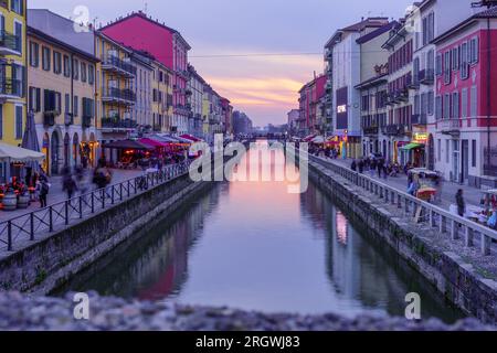 Mailand, Italien - 02. März 2022: Blick auf den Naviglio Grande Kanal bei Sonnenuntergang, mit Einheimischen und Besuchern, in Navigli, Mailand, Lombardei, Norditalien Stockfoto