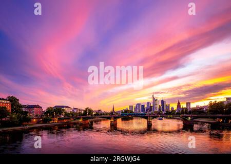 Blick auf Frankfurt bei Sonnenuntergang. Aufnahme mit Hintergrundbeleuchtung und Blick auf die Skyline. Hochhäuser von Banken und Versicherungsgesellschaften im Finanzdistrikt Stockfoto