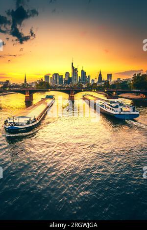 Blick auf Frankfurt bei Sonnenuntergang. Aufnahme mit Hintergrundbeleuchtung und Blick auf die Skyline. Hochhäuser von Banken und Versicherungsgesellschaften im Finanzdistrikt Stockfoto